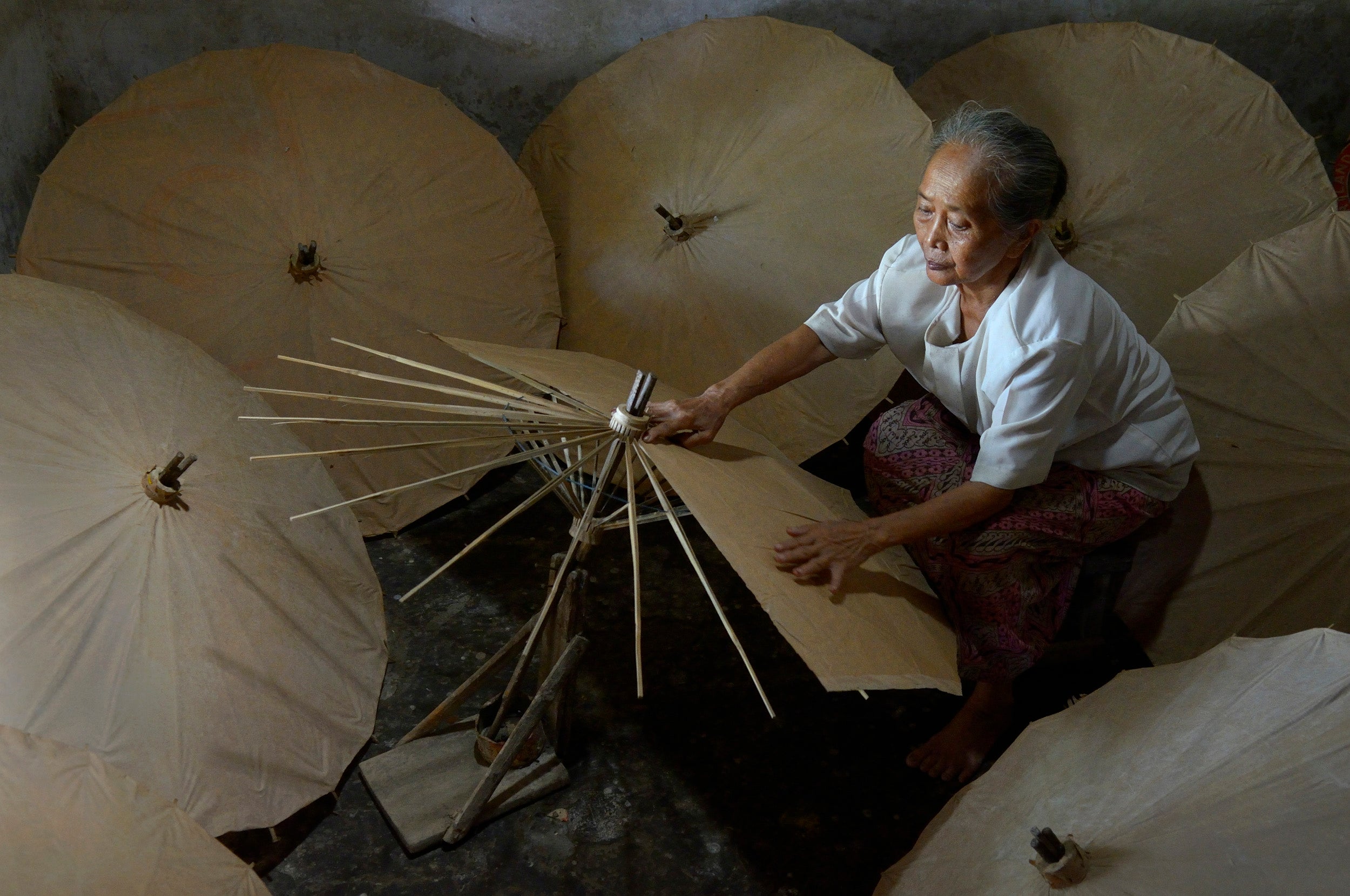 A lady makes traditional umbrellas.