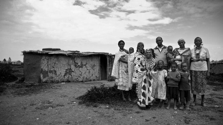 This Masai tribe stands outside their hut in Kenya.