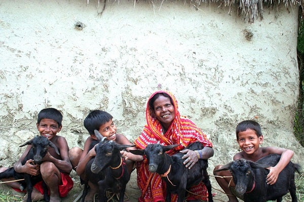 Woman smiles with her children and goats, India | Photo Credit: Papu Banerjee, 2015 CGAP Photo Contest