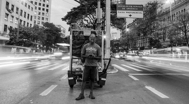 Man on street looks at mobile phone, Brazil