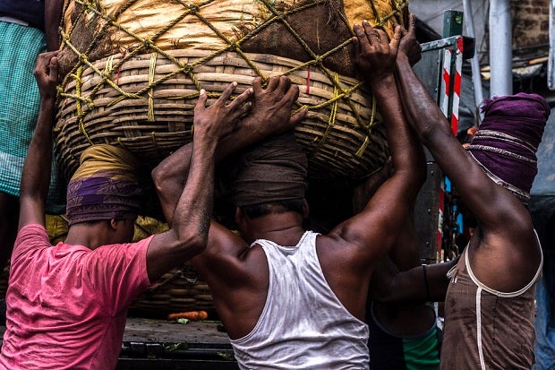 Laborers lift a basket, India. Photo by Sanjoy Ghosh, 2015 CGAP Photo Contest.