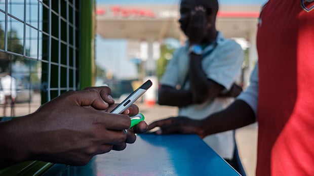 A mobile money agent in Zambia uses her smartphone