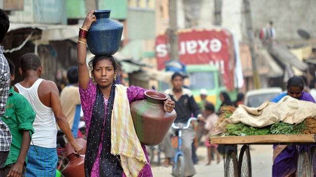 Woman carries water jugs