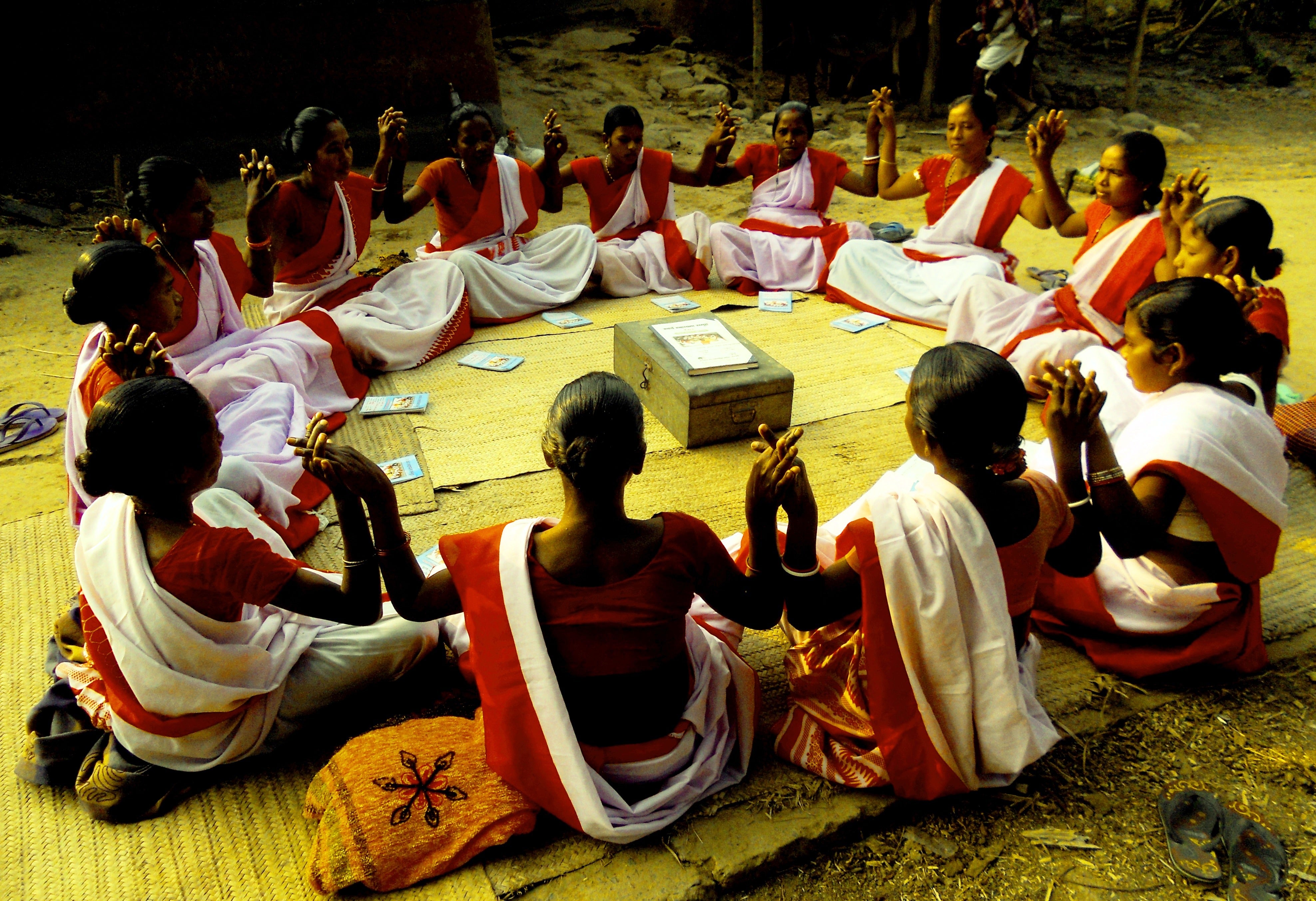 Women hold hands in a circle, India