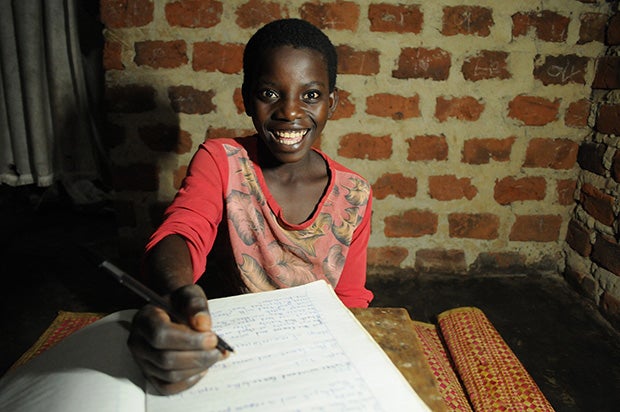 A Ugandan child using solar to study at night. Photo by Fenix International