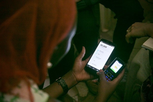 IDEO.org team gathered feedback on a smartphone-app prototype alongside a feature phone with a mobile-money agent. 
