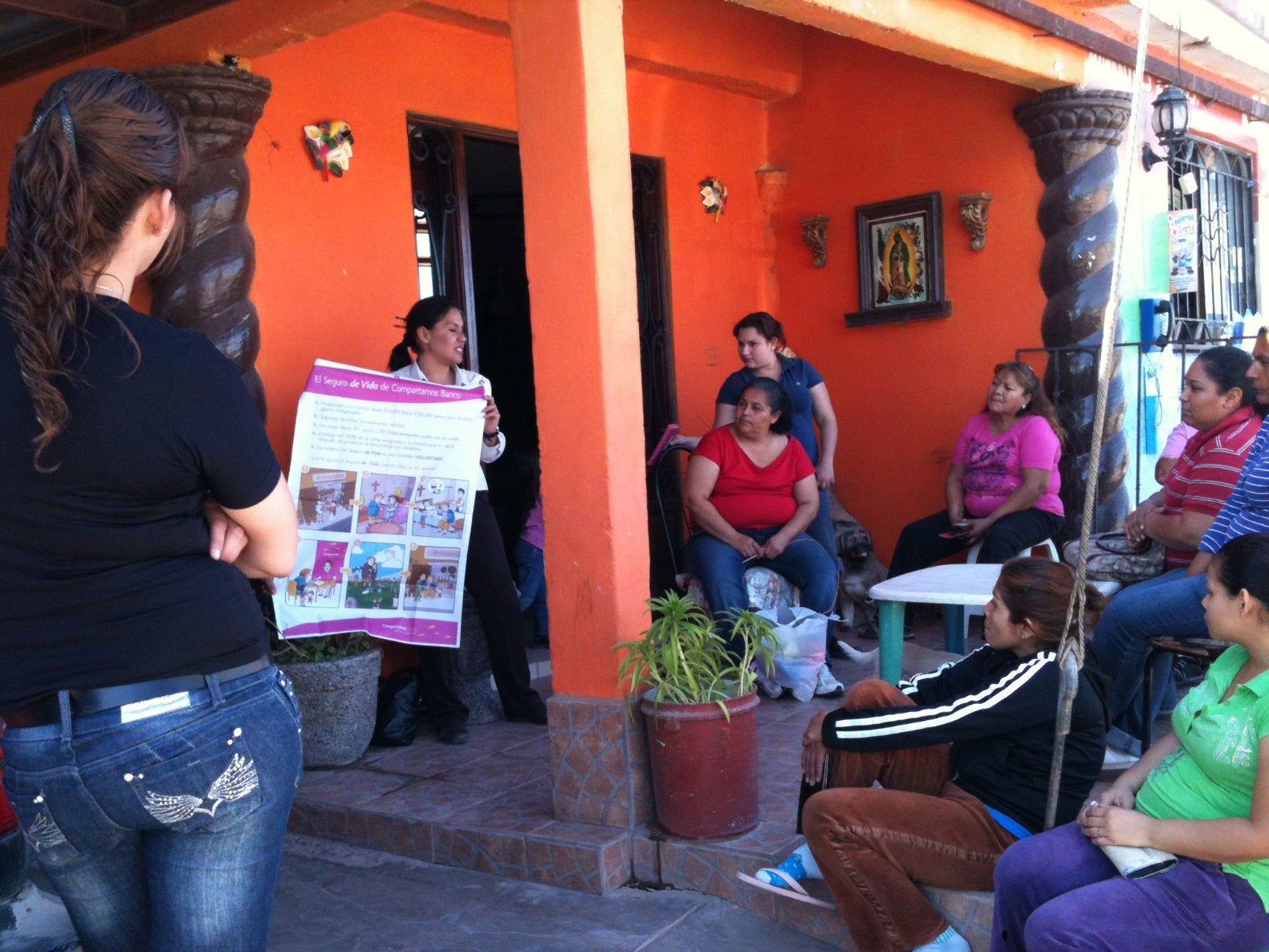 A loan officer sells insurance to a group of clients in Mexico.
