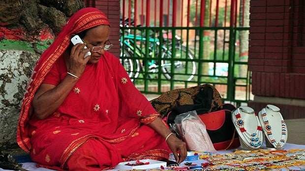 Street vendor in Bangladesh uses mobile phone
