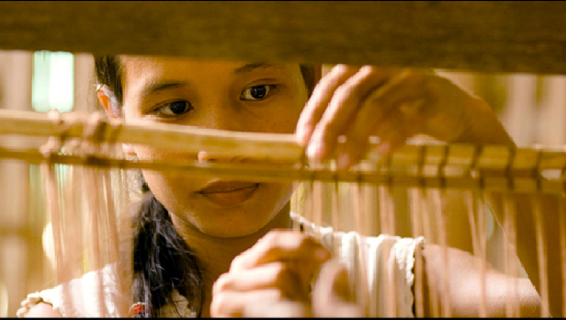 A weaver works on a loom.