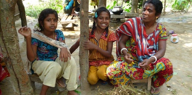 A Bangladeshi woman sits with her two daughters
