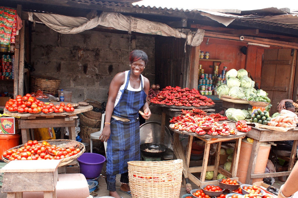 A woman stands in a stall selling red peppers