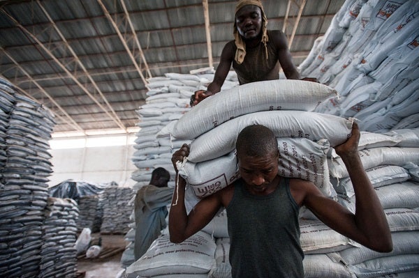 Men load bags of grain in a warehouse in Rwanda