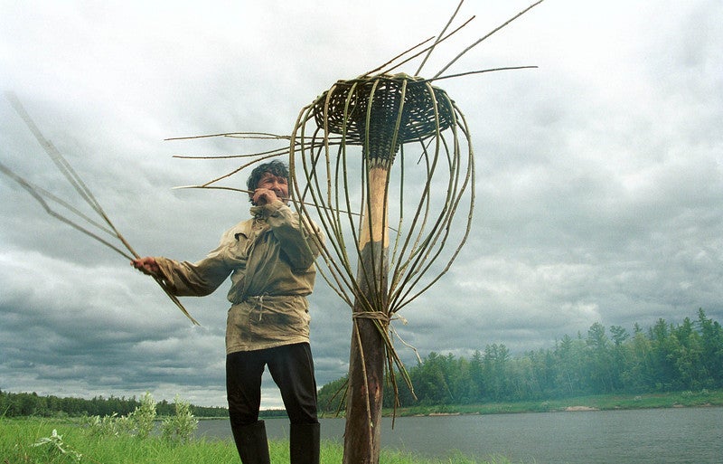 A fisherman weaves a basket