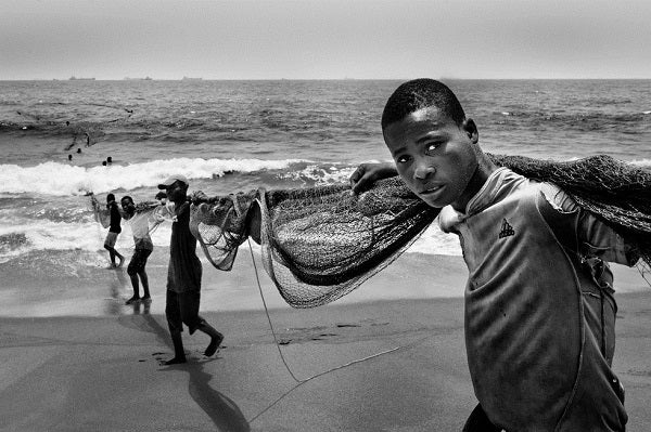 Togolese fishermen hold a net