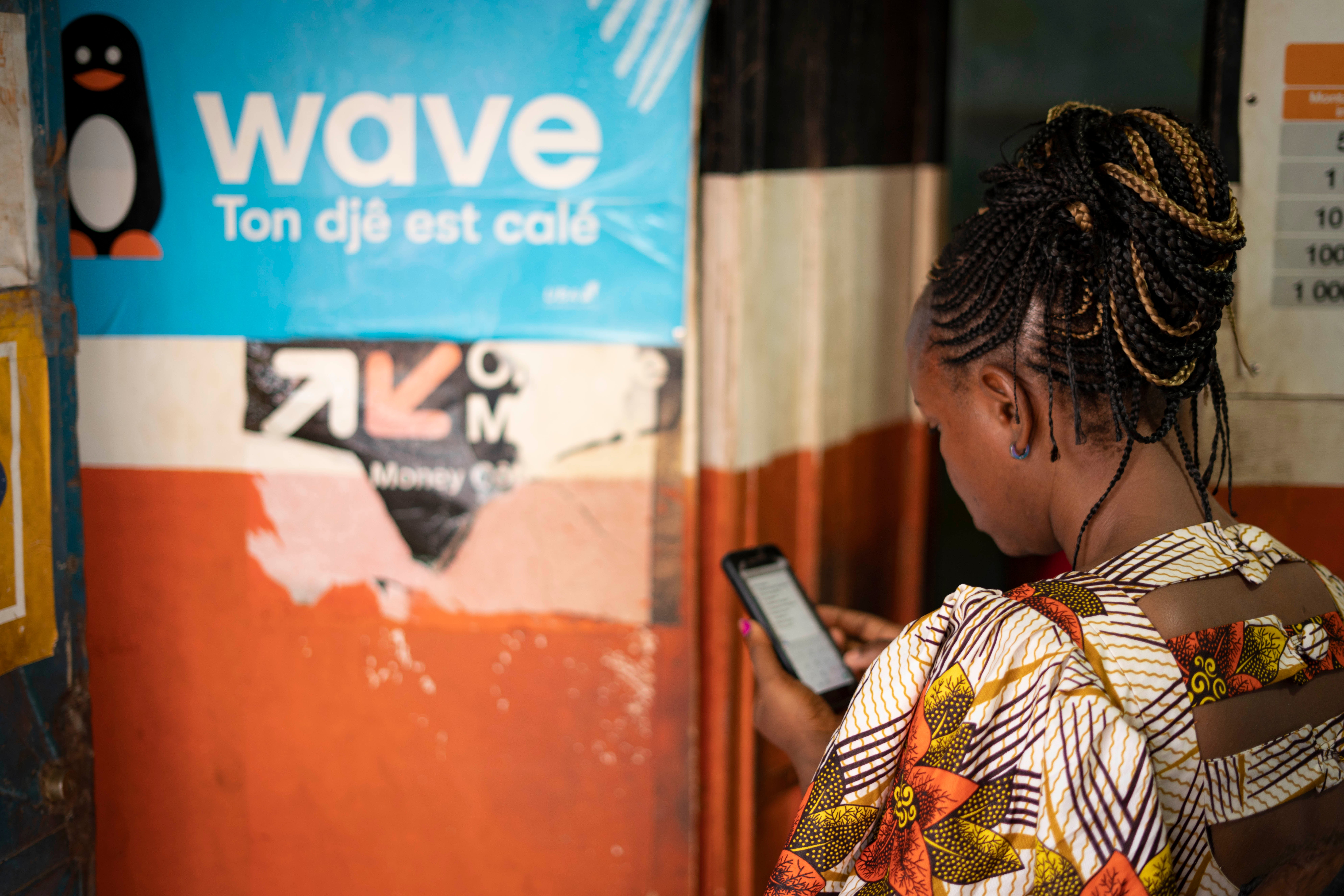 Woman uses her mobile to access digital financial services. Photo by Arete/Mamadou Diop