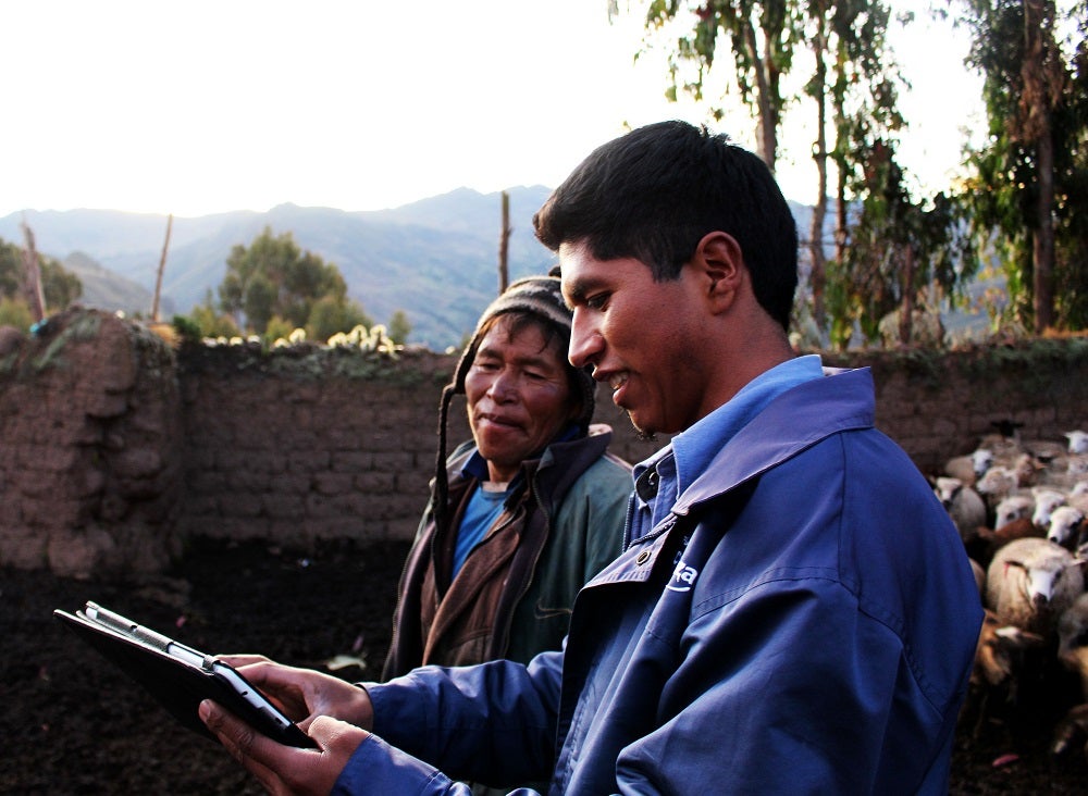 A microfinance officer speaks with a customer in rural Peru.