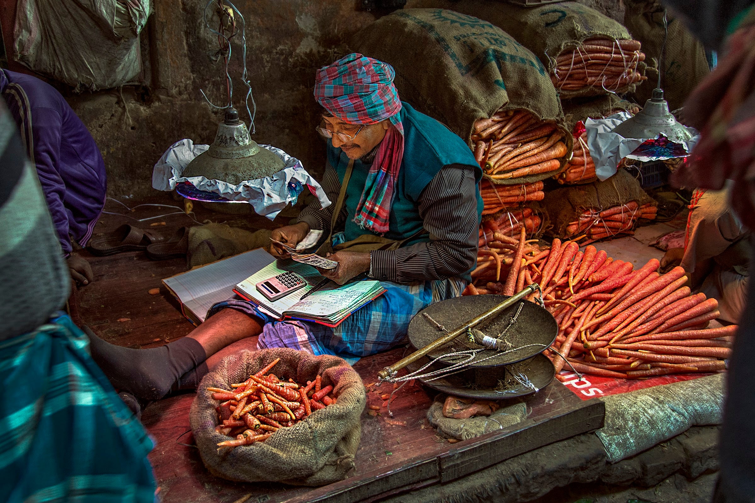A carrot merchant in India counts his cash at the end of the day. Photo: Subrata Adhikary, 2017 CGAP Photo Contest