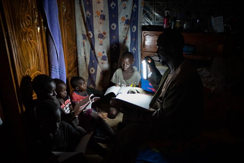 Using solar-powered light from a pay-as-you-go kit, Mali.