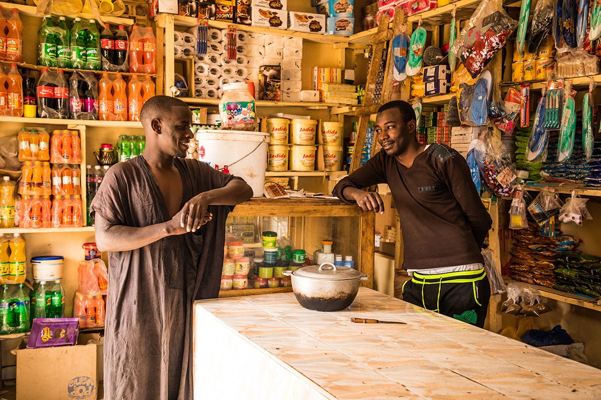 A shopkeeper chats with his customer in rural Senegal. Photo: Vincent Tremeau / World Bank