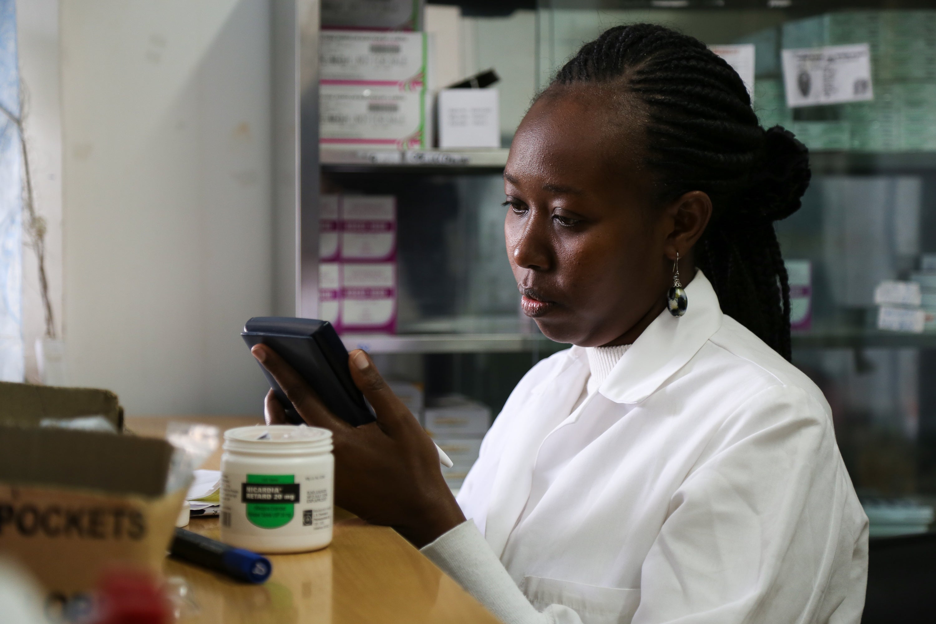 A pharmacist assists a customer in Kenya.