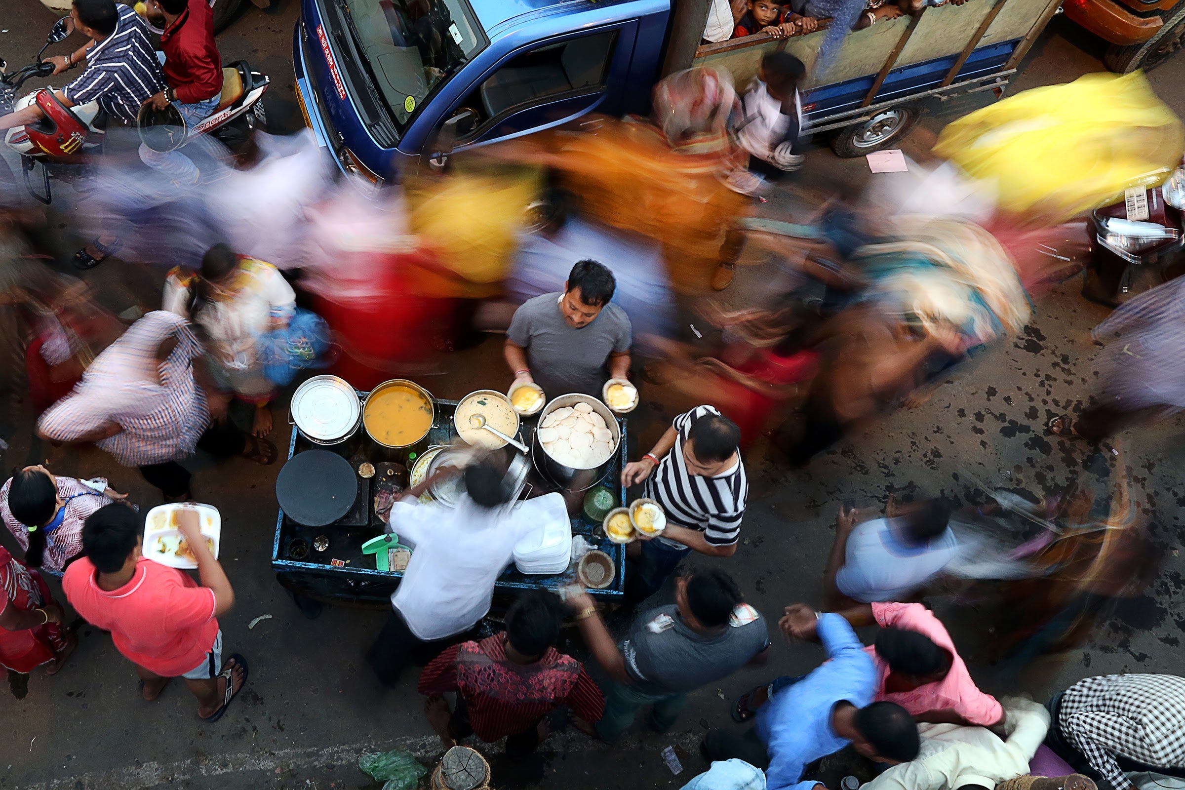 Street vendors serve food on a busy street