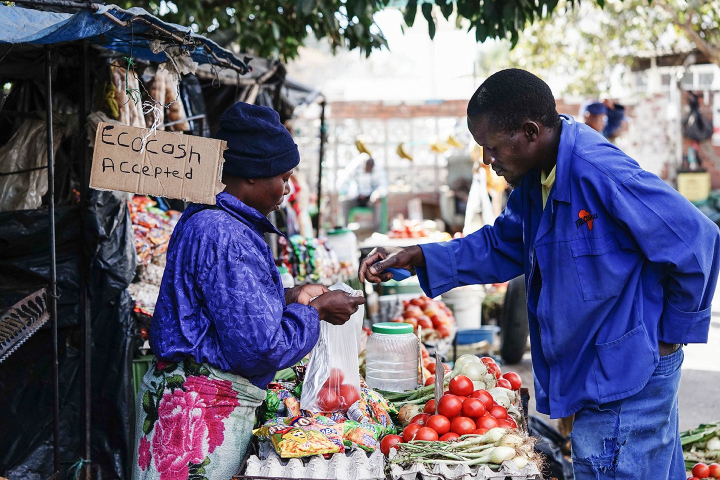 A customer buys tomatoes with mobile money in Zimbabwe. Photo: Zinyange Auntony, 2018 CGAP Photo Contest