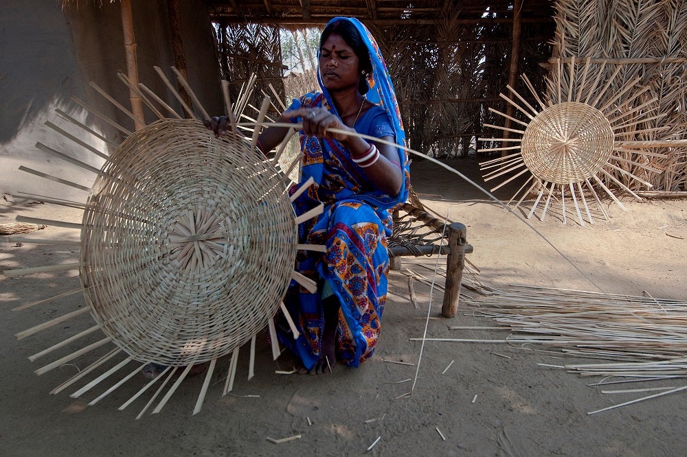 A woman weaves a basket