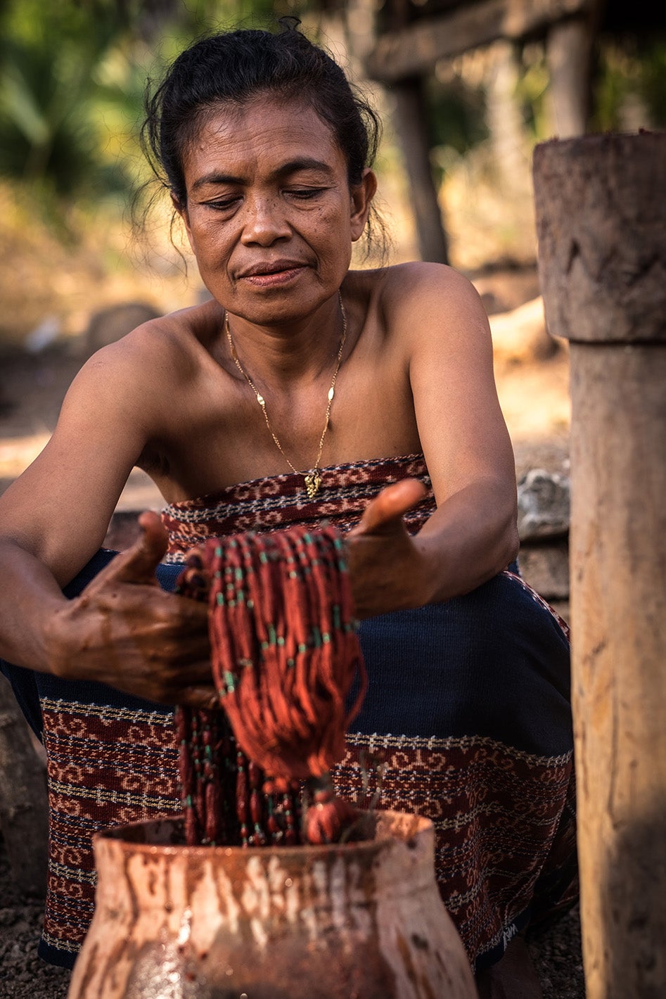 A woman dyes threads for her weaving cooperative in Indonesia. Photo: Debra Wallace, 2017 CGAP Photo Contest