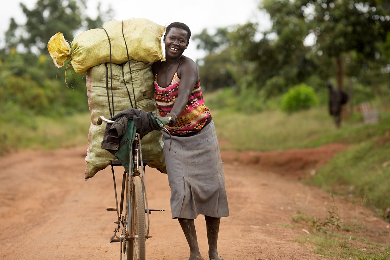 A woman uses a bicycle to take her produce to market in rural Uganda.