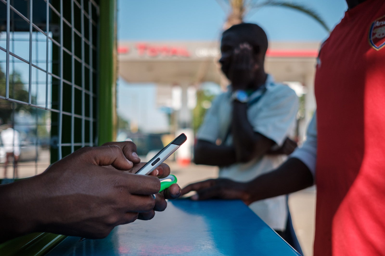 A teller holds a smartphone in Zambia. Photo: Nyani Quarmyne, IFC