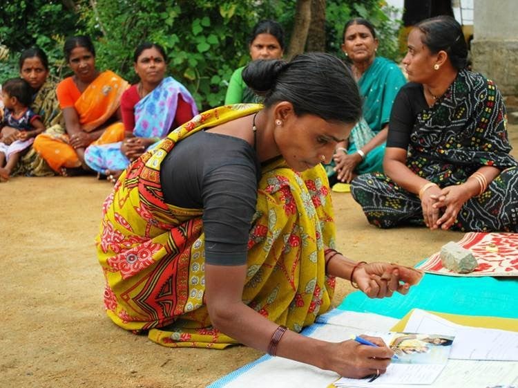 A woman signs microfinance loan documents with SKS in 2008.