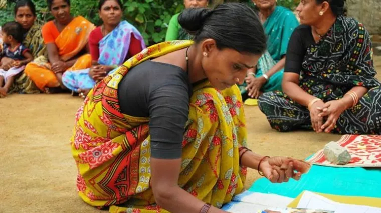 Woman signs a microfinance loan document 