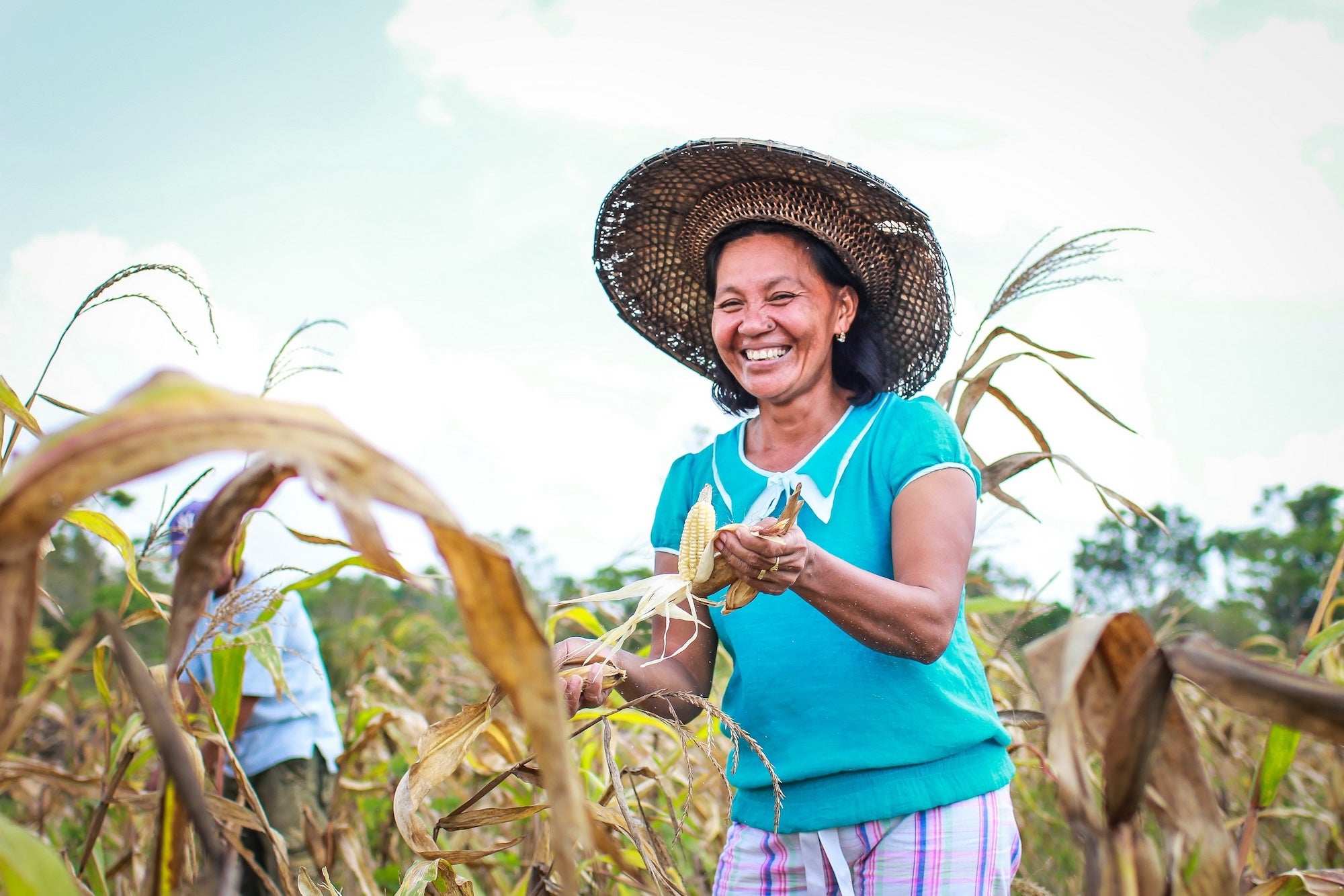 A woman smiles in a field in the Philippines