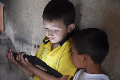 two young boys looking at a tablet screen