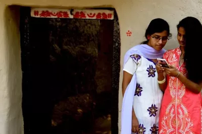 Two women use a mobile phone