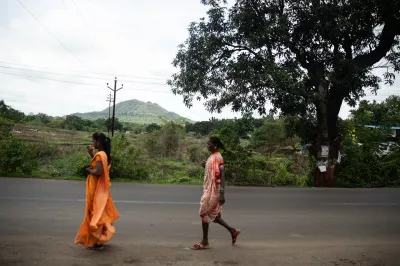 Two women walk a rural road in India