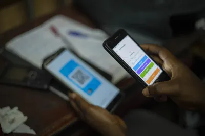 A person holds a mobile phone looking at a mobile money screen