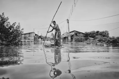 A woman paddles a makeshift raft during a flood