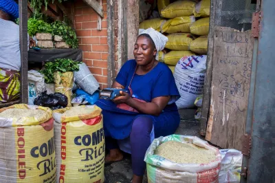A woman market vendor uses digital finance tools