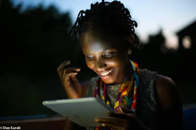 A Tanzanian woman looks at a tablet screen