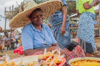 A woman smiles at a market stand