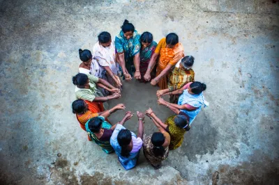 a group of women standing in a circle with their hands together in the center