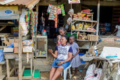 A woman and two girls look at a phone