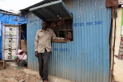 Man stands outside small shop, Kenya.