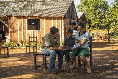 Family reading outdoors, Paraguay