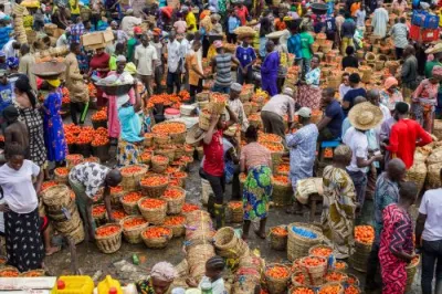 People buy and sell tomatoes in bulk at an otdoor market in Lagos, Nigeria