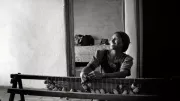 A woman weaving mats