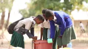 Residents of a small village in Tanzania draw water.