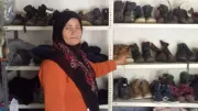 Microfinance borrower stocking the shelves of her clothing store in Lebanon