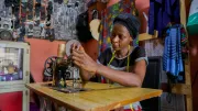 a woman setting up her sewing machine in her shop in Nigeria